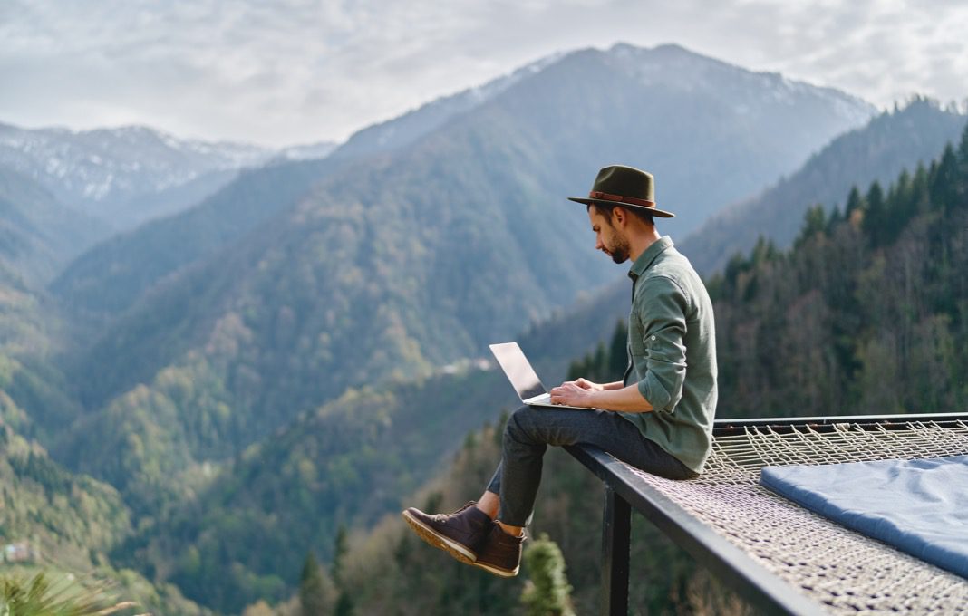 Employee engaging in remote work from a mountaintop.