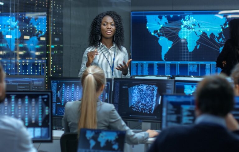 Chief Project Engineer Holds Briefing for a Team of Scientists that are Building Machine Learning System. Displays Show Working Model of Neural Network.