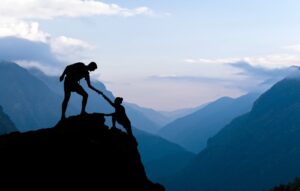 Teamwork couple climbing helping hand