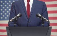 Businessman at podium in front of American flag