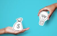 One hand offering an illustration of a cash bag to another hand holding a lightbulb on a blue background