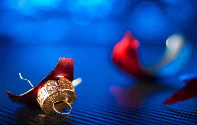 Broken red Christmas ornament and festive blue background reflecting the depression of some during the holidays