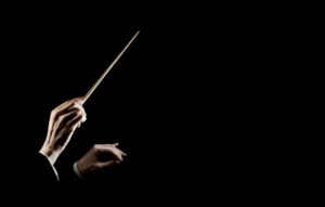 Orchestra conductor music conducting. Hands of conductor with baton