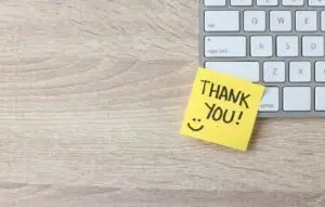 Thank you sticky note on a keyboard