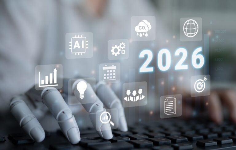 Human and robot hand typing with digital screen showing 2026