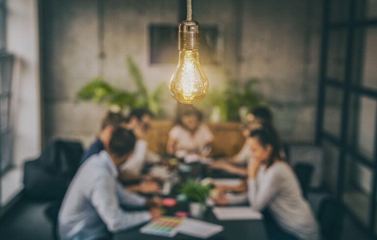 business people meeting at office with a lightbulb in the foreground