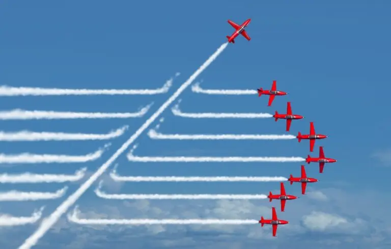 One plane cutting through the trails of a line of other planes flying through the sky