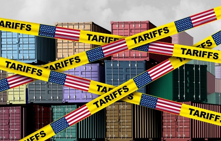 Caution tape printed tariffs in front of shipping containers