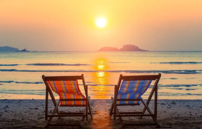 Pair of beach loungers on the deserted beach at sunset.