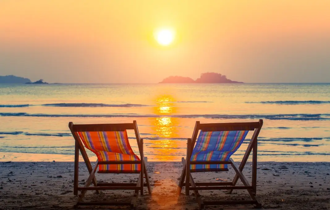 Pair of beach loungers on the deserted beach at sunset.
