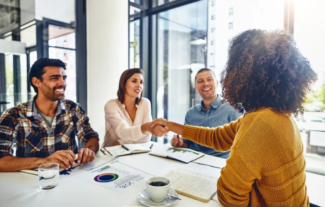 Happy people and shaking hands with new employee