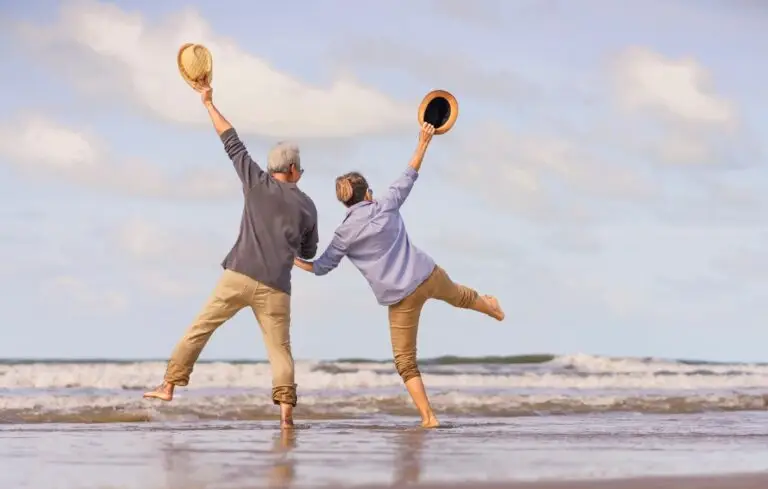 senior couple jumping on the beach