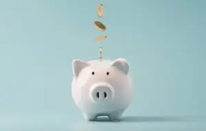 Coins falling to white piggy bank