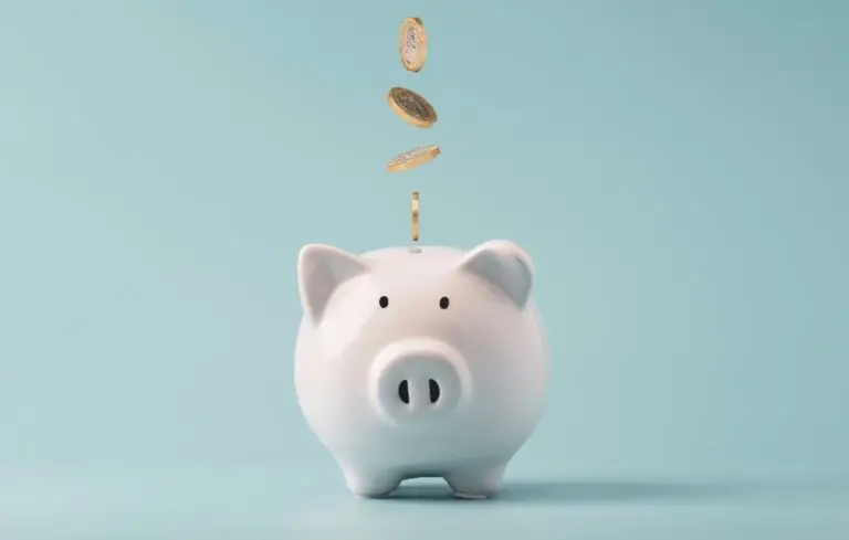 Coins falling to white piggy bank