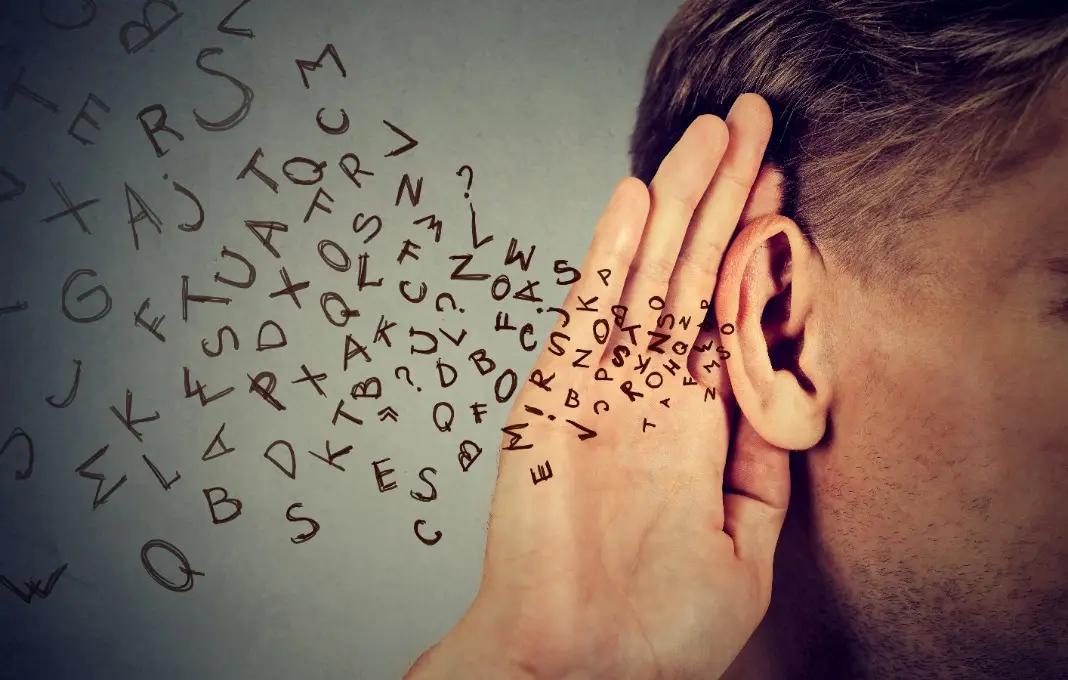 man holds hand near ear listens carefully alphabet letters flying in