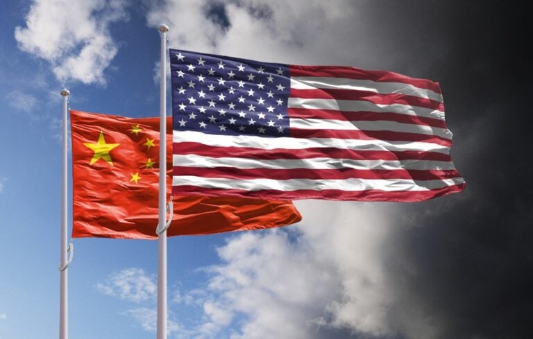 Flags of China and US above dark sky.