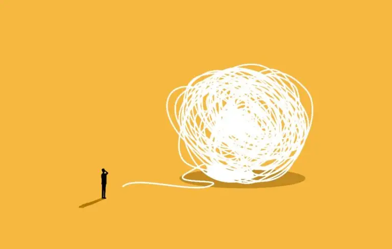 Businessman looking at big tangled ball of string