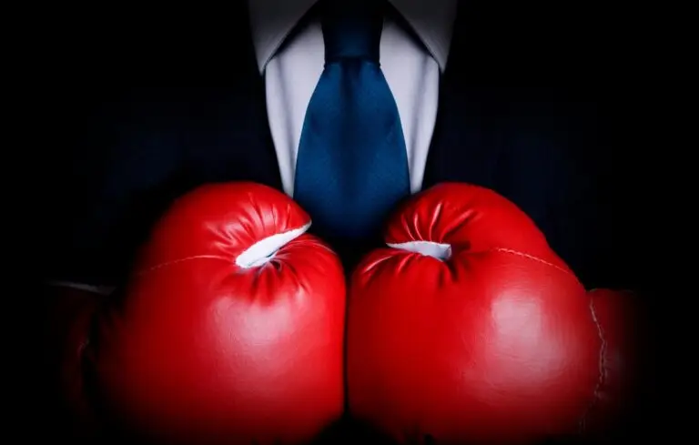 person in suit wearing red boxing gloves