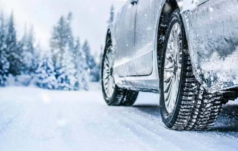 Winter tire. Car tire on snow road. Tires on snowy road detail.
